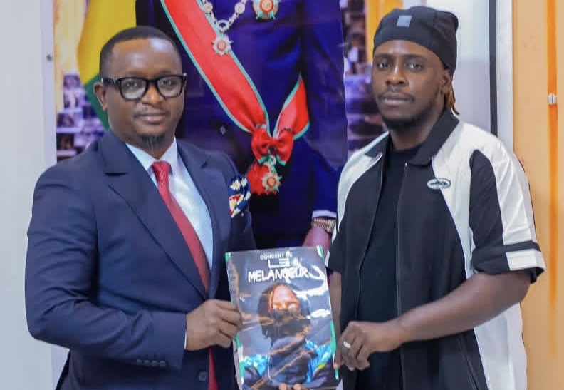 Le Mélangeur et le ministre de la Culture tenant l’affiche du concert du stade Petit Sory